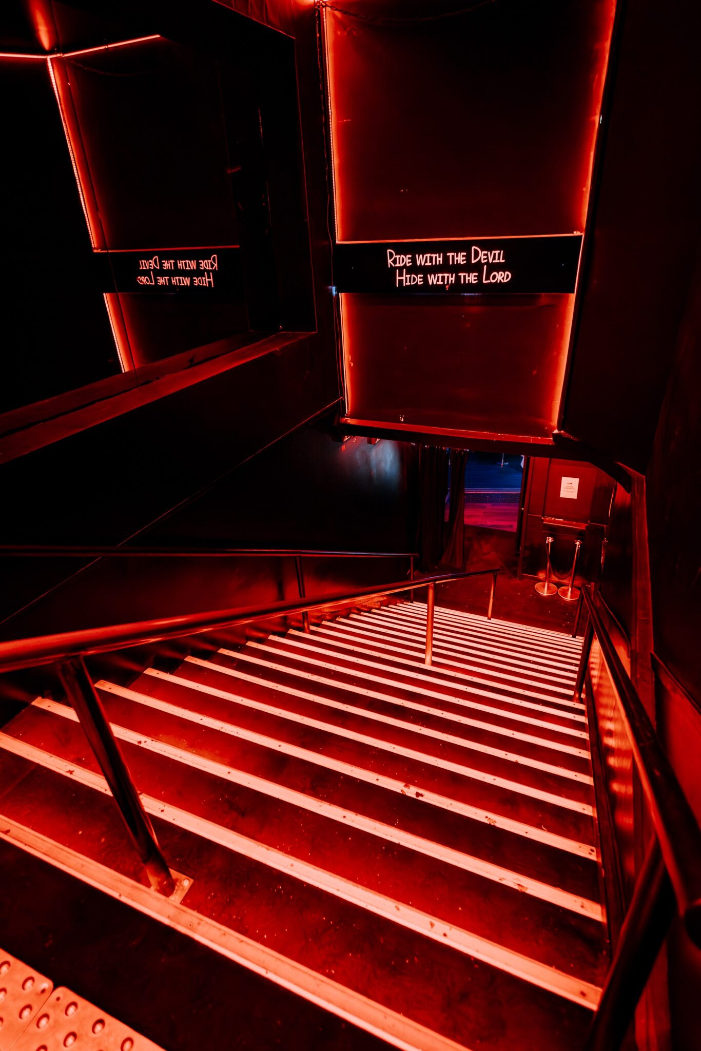 Le Cova — l'escalier baigné de lumière rouge