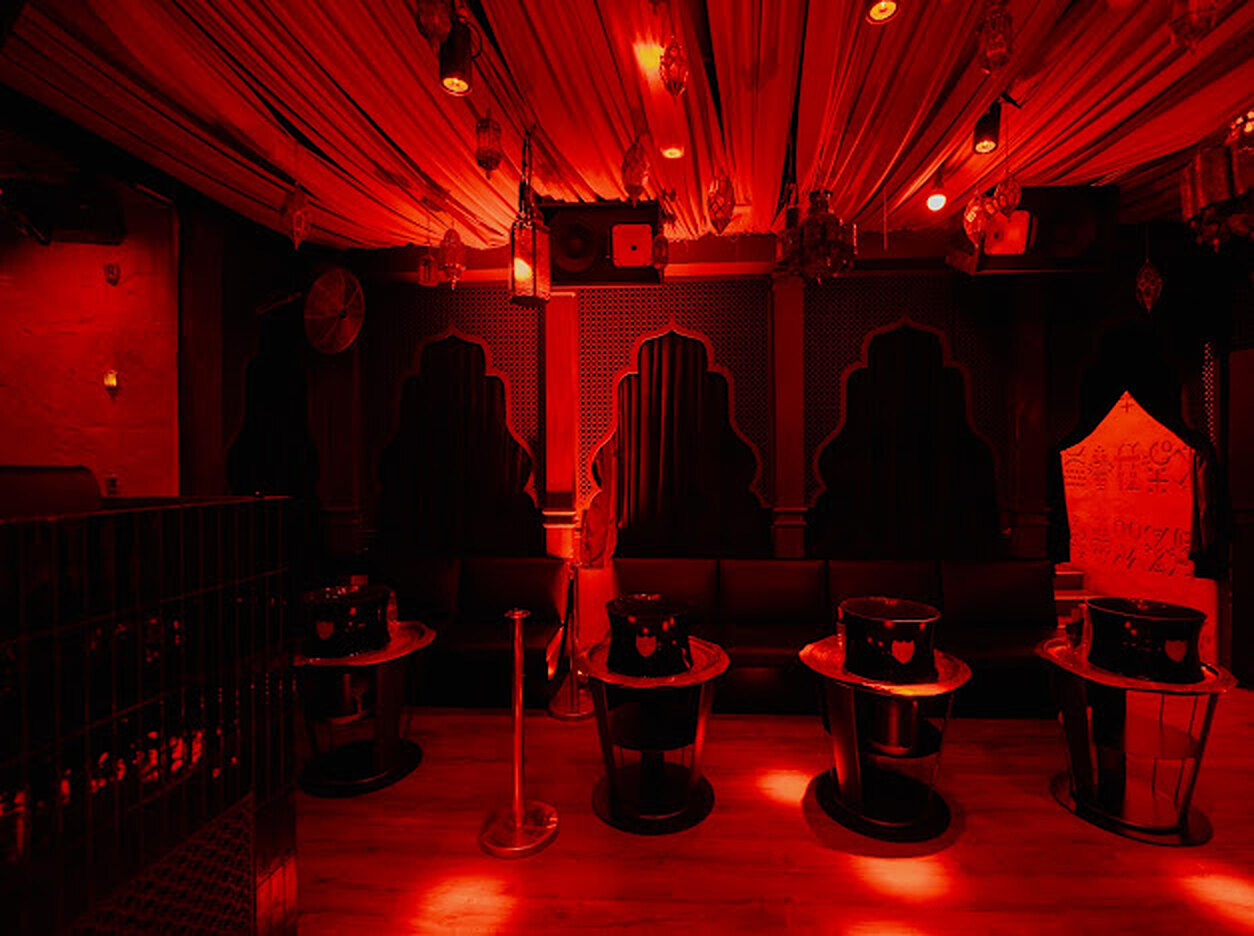 Le Mirage — la salle sous ses tentures rouges, tables lumineuses